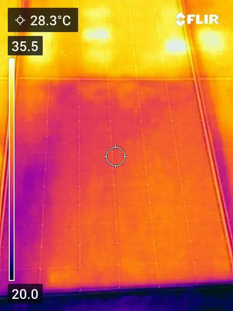Thermal image of a cleaned module reading 28.3 °C at the crosshair, with a warmer uncleaned module behind it